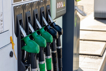 Close-up of fuel pump nozzles at gas station. Detailed view of multiple green and black fuel pump...