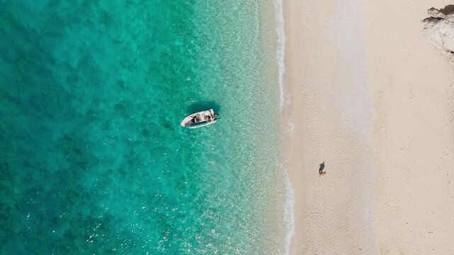 Aerial top down static of a man walking on white sand of Platis Ammos Beach in Ithaca island, Greece