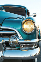 Fototapeta premium Vintage car front view highlighting teal finish and chrome