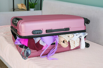 A suitcase with belongings a lot of clothes on the trip.