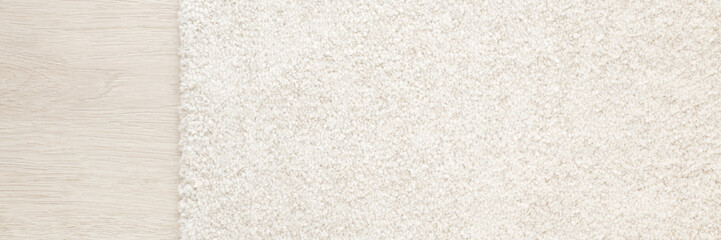 White new fluffy home carpet on light color laminate background. Wide banner. Closeup. Empty place for text. Top down view.