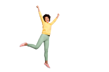 Full length photo of delighted crazy mulatto girl win fall autumn jackpot sales discounts jump raise fists scream yeah wear yellow pullover green pants trousers isolated over purple color background
