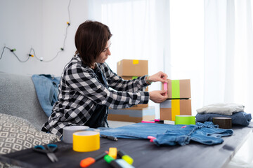 Girl Prepares A Cardboard Box For Shipping And Sticks A Sticker On It