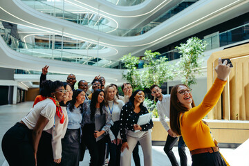 Cheerful business team taking a selfie in modern office atrium