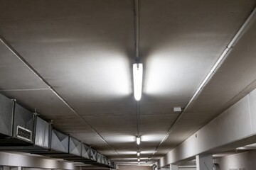 Ventilation system and lighting illuminating concrete ceiling in parking garage