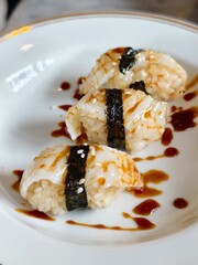 Three engawa sushi on white plate.