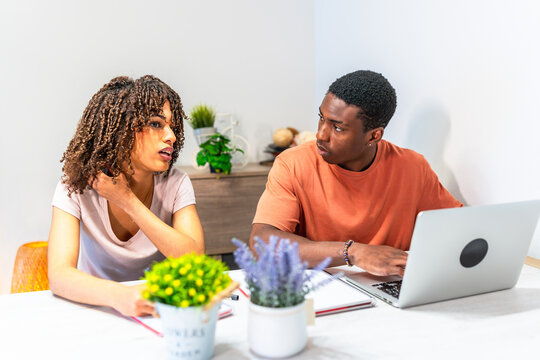 Young students working on project together at home using laptop