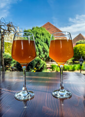 Refreshing Beverages: Two Full Glasses Outdoors on a Bright Day.Relaxing Afternoon: Pair of Drinks on Patio Table. Cheers. Two Stemmed Glasses with Cold Drink Ready for Enjoyment Outdoors