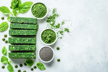 Flat lay of spirulina bars with powder, chia seeds and spinach