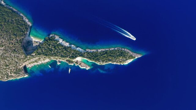Flyover of curved coastline and clear waters at Hulla Beach, Ithaca Island