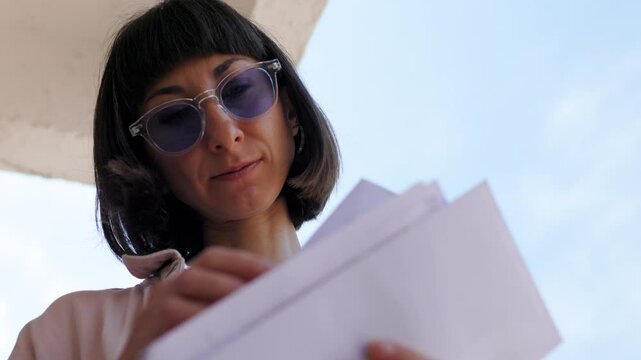 Close-up of envelopes. Girl receiving mail, looking at correspondence notification, bank account notification.