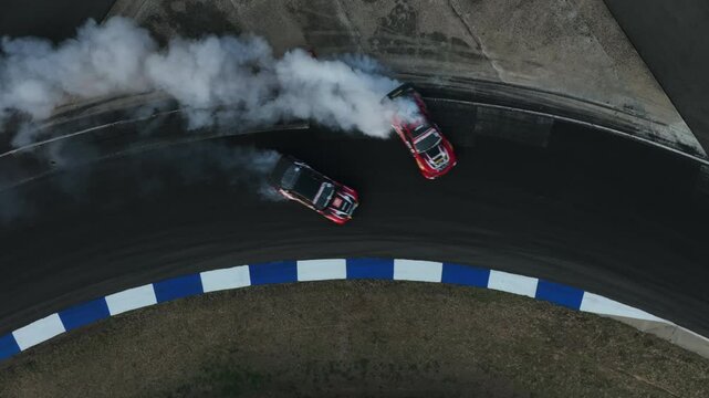 Aerial view car drift on asphalt race track with lot of smoke from burning wheel tires rubber, Drift motorsport car drift race, Professional driver drift car on asphalt race track, Car motion blurred 