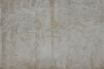 A neutral-toned wall displays intricate, abstract patterns created by various textures and subtle color variations.