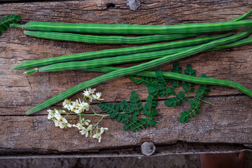 Healthy drumstick pods vegetable and leaves. Moringa Oleifera with leaves on wooden background