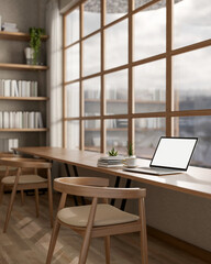 White screen laptop on long table under a glass wall next to large bookshelf. library or study room