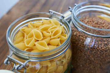 Pasta in a glass jar on a wooden background. Selective focus.