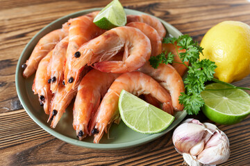Shrimps with lime and parsley on plate, closeup