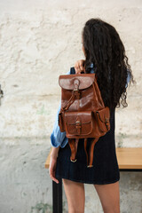 A Chic Outfit Featuring a Bright Brown Backpack Paired with Stylish and Trendy Dress and Blue Shirt