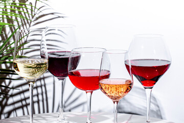 Non-alcoholic, alcohol free wine set. Red, white, rose wines in glasses. White background, shadows, hard light