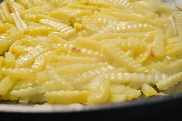 Fresh potato chips frying. Frying potatoes.  Shallow depth of field.