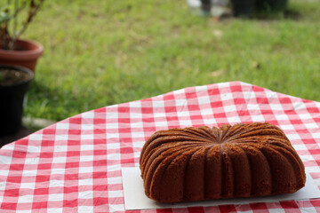 Bolu gula aren. Delicious brown butter cake with elegant swirl pattern on top, placed on a red...