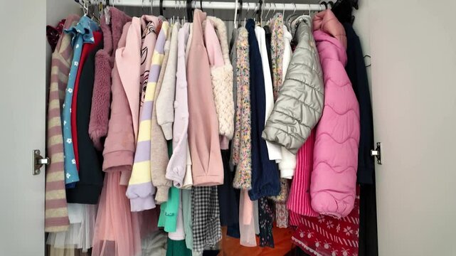 Video of open children's wardrobe full of colorful girls' clothes