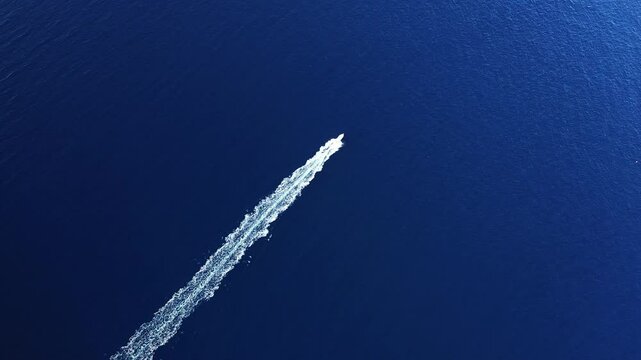 A tourist boat sails through the Calanques de Piana, in Europe, in France, in Corsica, towards Ajaccio, on the edge of the Mediterranean Sea, in summer, on a sunny day.&nbsp;