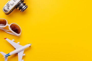 Travel-themed flat lay with toy airplane, camera, and sunglasses