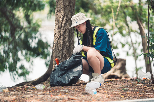 Volunteer young girl joins a community cleanup, helping recycle and protect nature during a volunteer driven Earth Day event. - Powered by Adobe