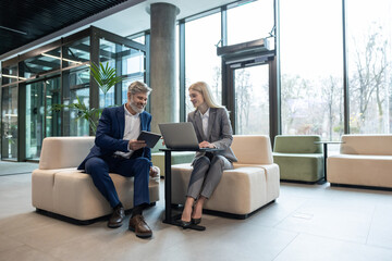 Bearded male and blonde female colleagues employees brainstorming working together on computer