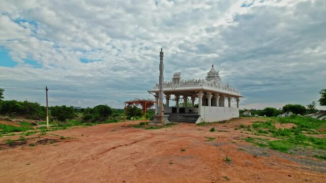 rainy clouds with newly constructed Hindu temple and dwajasthambam day time, low angle, semi circle, drone shot, 4k.