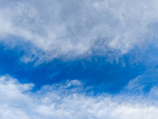 Blue sky with dramatic white and gray cloud formations, creating a textured and atmospheric natural...