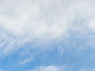 Blue sky with dramatic white and gray cloud formations, creating a textured and atmospheric natural scene