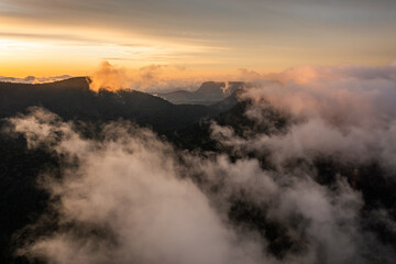 mountain landscape with morning golden light above low clouds