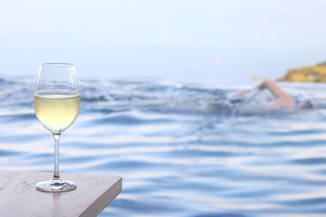 glass of cold white wine on the summer seashore by the water, relaxing by the water, a gentle background of soft color