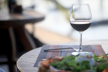 dinner in a restaurant with wine, beautiful table setting, a glass of wine in the foreground