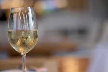 a glass of cold white wine and serving in the restaurant