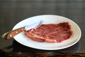 a piece of raw meat, steak on a plate, beef