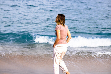 Woman with continuous glucose monitor walking on the beach