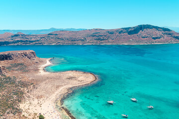 Sailboats anchored near a stunning turquoise beach