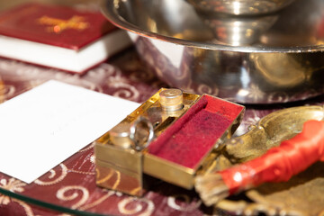 Close-up of Orthodox Baptism Ritual Items: Oil, Book, and Bowl