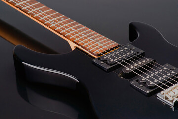 Fototapeta premium Close up of sleek black electric guitar with wood neck