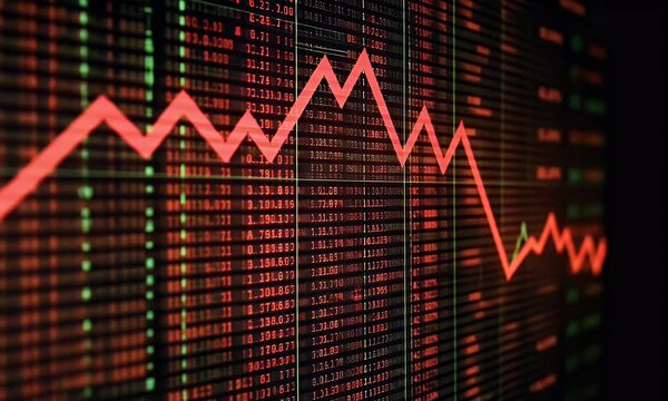 The stock market graph is declining, with a red arrow pointing downward on the digital screen
