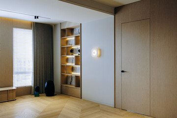 Cozy living room with wooden floor, shelves, and natural light