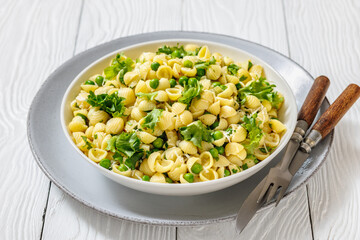 Pasta with green peas in a bowl, italian cuisine