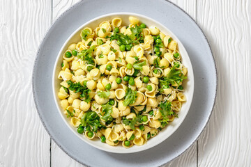 Pasta with green peas in a bowl, italian cuisine