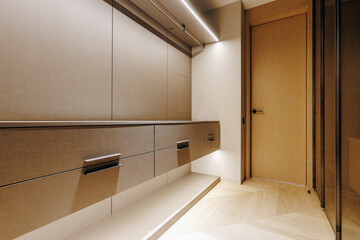 A spacious and organized walkin closet featuring many drawers and a door