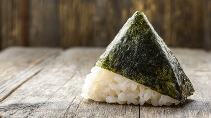 A shot of a rice ball in the shape of a triangle, wrapped in seaweed and placed on a traditional wooden table, with soft light illuminating the details