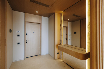 A hallway featuring a mirror mounted on the wall along with a door