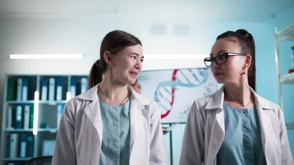 medical conference, young female medical staff in surgical gowns walking in modern laboratory